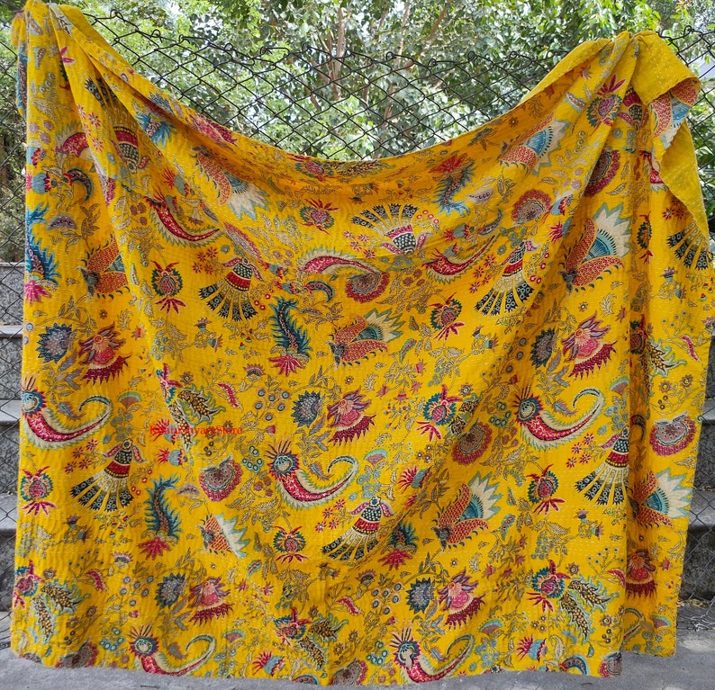 K&ouml;nnte beinhalten: Eine gelbe Kantha-Steppdecke mit einem floralen und Paisley-Muster in Rot-, Blau- und Gr&uuml;nt&ouml;nen.