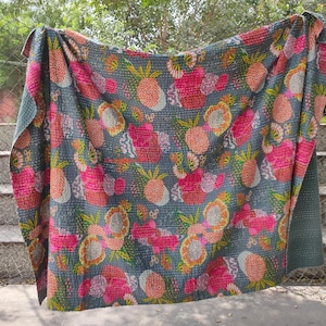Könnte beinhalten: Eine graue Kantha-Steppdecke mit einem floralen und Ananas-Muster in Rosa-, Gelb- und Grüntönen. Die Steppdecke ist aus Baumwolle und handgenäht.