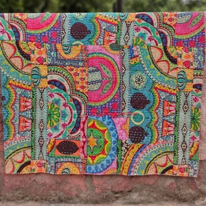 Puede incluir: Una colcha de retazos colorida con una variedad de patrones florales y geom&eacute;tricos en tonos de rosa, azul, verde, amarillo y naranja. La colcha est&aacute; hecha de tela de algod&oacute;n y est&aacute; acolchada con una puntada corrida.