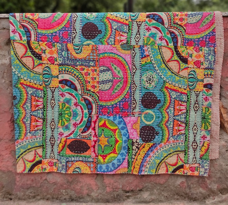 Puede incluir: Una colcha de retazos colorida con una variedad de patrones florales y geom&eacute;tricos en tonos de rosa, azul, verde, amarillo y naranja. La colcha est&aacute; hecha de tela de algod&oacute;n y est&aacute; acolchada con una puntada corrida.
