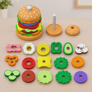 May include: A toy hamburger stacking set featuring a tan bun base with a central post, various colorful plastic food-shaped rings representing ingredients like lettuce, tomato, cheese, and meat, and a matching tan bun top piece.