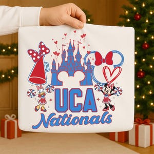 May include: White square pillow with a colorful design featuring a castle, Minnie Mouse, Daisy Duck, and the text "UCA Nationals." The design includes red and blue accents, hearts, and pom-poms.