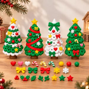 May include: Four miniature Christmas tree figurines with removable ornaments including hearts, stars, bows, snowflakes, candy canes, and holly berries. The trees are green and white, each topped with a yellow star and set on a brown base.