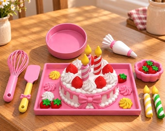 May include: A toy cake set featuring a pink tray, a round cake with white frosting, red strawberries, and striped candles. Includes a pink whisk, a yellow and pink spatula, a piping bag, a pink bowl, a small pink dish with strawberries, and two extra candles.