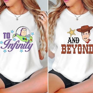 Puede incluir: Camisetas blancas con gráficos de dibujos animados. Una camiseta muestra a Buzz Lightyear en una nave espacial con el texto "To Infinity". La otra camiseta muestra a Woody con una placa de sheriff y el texto "And Beyond".