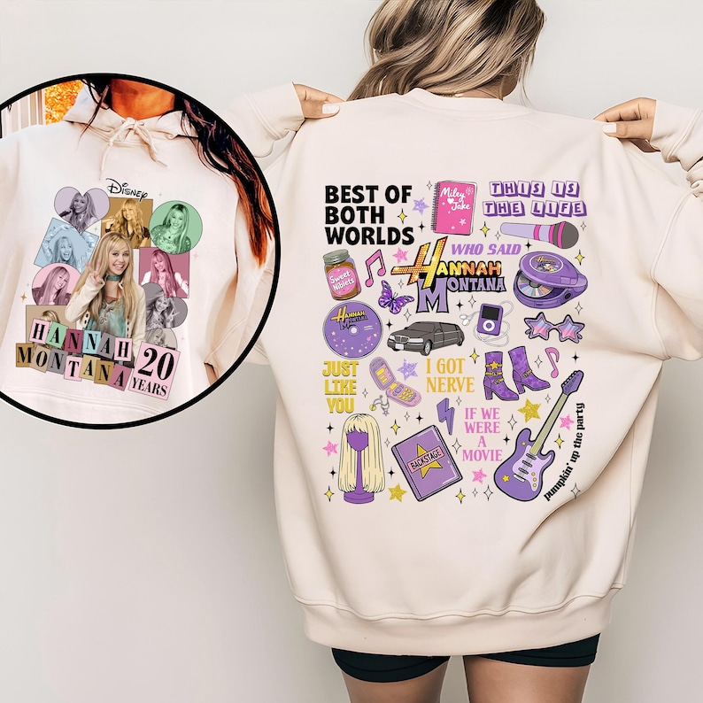 Puede incluir: Sudadera crema con un dise&ntilde;o de Hannah Montana. La parte delantera presenta un collage de fotos con "Hannah Montana 20 Years". La parte trasera tiene gr&aacute;ficos y texto, incluyendo "Best of Both Worlds" e iconos relacionados.