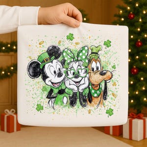 Könnte beinhalten: Ein weißes quadratisches Kissen mit Mickey Mouse, Minnie Mouse und Goofy in St. Patrick's Day-Kleidung. Die Charaktere tragen grüne Hüte, Fliegen und Accessoires, mit Kleeblättern und Goldmünzen verstreut.