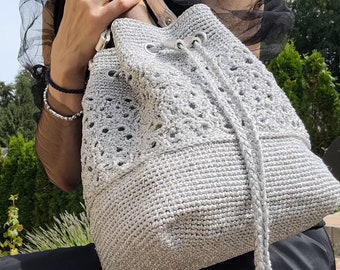 Eine Häkeltasche mit Blumenmuster aus metallic Garn. Abendtasche.
