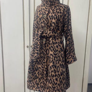 May include: A brown and black leopard print coat with a high collar, a belt, and gold buttons.