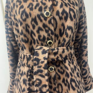 May include: A brown and black leopard print coat with a gold button closure and a matching belt.
