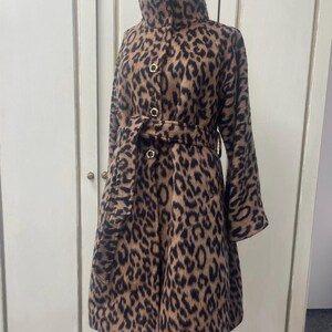 May include: A brown and black leopard print coat with a high collar, a belt, and gold buttons.