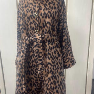 May include: A brown and black leopard print coat with a high collar, a belt, and gold buttons.