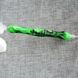 May include: Green and black diamond painting pen with a clear plastic tip and a suction cup on the end.