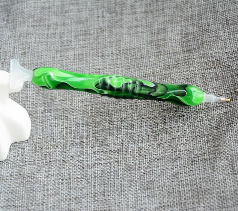 May include: Green and black diamond painting pen with a clear plastic tip and a suction cup on the end.