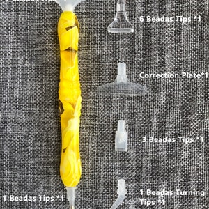 May include: A set of diamond painting tools including a yellow and white pen with nine tips, a correction plate, and six, three, and one bead tips.
