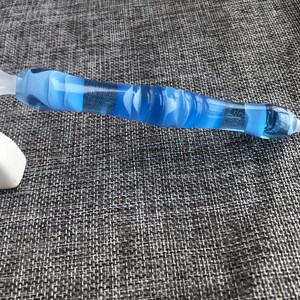 May include: A blue and white diamond painting pen with a clear plastic handle and a pointed tip.