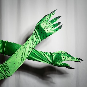 May include: A pair of long green satin gloves with black polka dots and black claw-like fingertips.