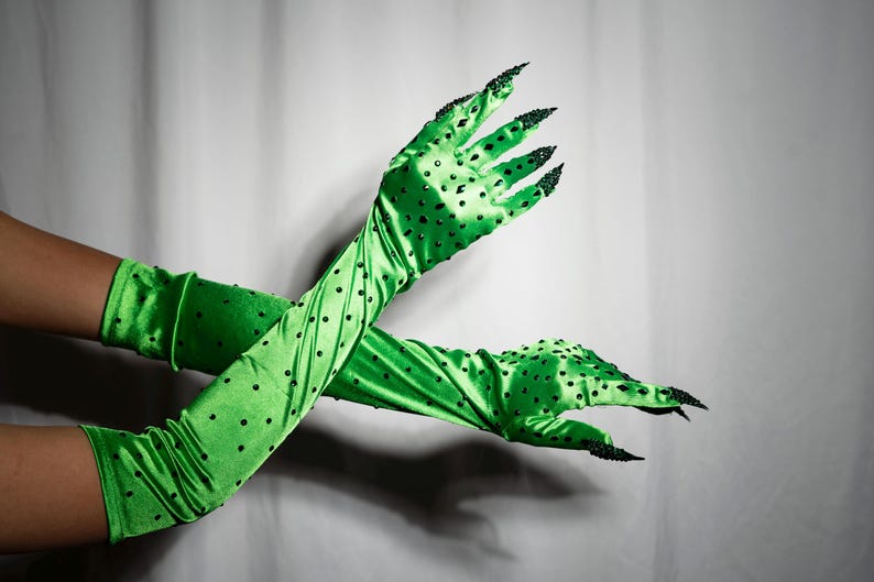 May include: A pair of long green satin gloves with black polka dots and black claw-like fingertips.