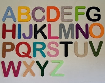 May include: Felt alphabet letters in various colors, including blue, pink, green, orange, red, yellow, purple, and black. The letters are arranged in alphabetical order.