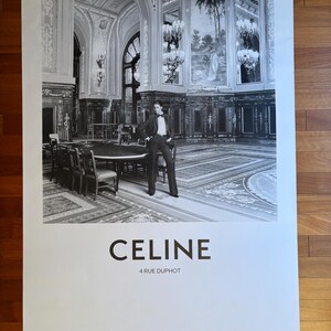 May include: Monochrome poster showing a person in a suit in a lavish room with chandeliers and a large table. The word "CELINE" is printed in bold letters, with "4 RUE DUPHOT" beneath it.