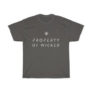 May include: A dark gray t-shirt with a white geometric design and the text "PROPERTY OF WICKED" printed on the front.
