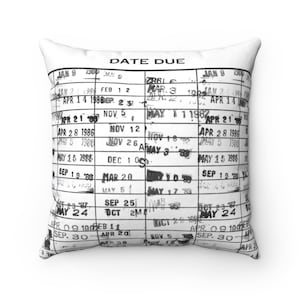 May include: A white cushion featuring a black and white image of a date due calendar. The calendar has dates and months printed on it, with some dates marked out.