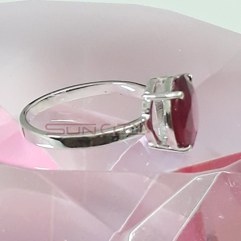 May include: A silver ring featuring a large, heart-shaped ruby gemstone.