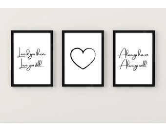 Op de afbeelding: Drie zwarte ingelijste prints met witte achtergronden. De linker print heeft de tekst "Loved you then Love you still..." De middelste print heeft een zwarte hartvorm. De rechter print heeft de tekst "Always have Always will".