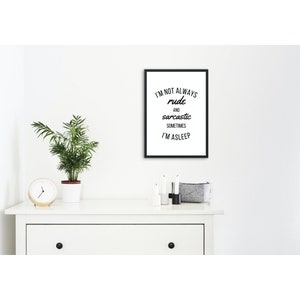 Può includere: Una stampa in bianco e nero incorniciata con il testo "I'M NOT ALWAYS rude and sarcastic SOMETIMES I'M ASLEEP" è esposta su un comò bianco. Una piccola pianta in vaso, un orologio, candele e un cestino in feltro grigio sono anche sul comò.