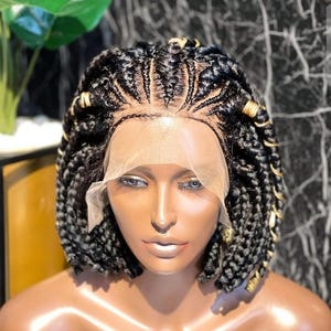 Puede incluir: Una peluca negra trenzada con cuentas doradas, con estilo bob corto con encaje frontal.