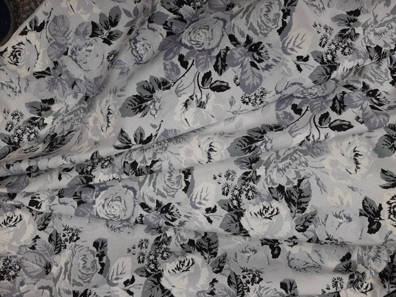 Puede incluir: Una tela blanca con estampado floral negro y gris. La tela presenta un patr&oacute;n repetitivo de rosas y hojas.