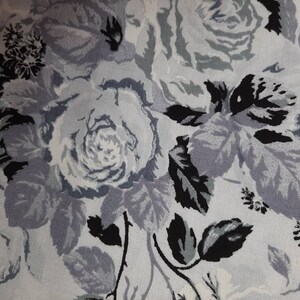 Puede incluir: Una tela blanca con un patr&oacute;n floral negro y gris. El patr&oacute;n presenta rosas y hojas.