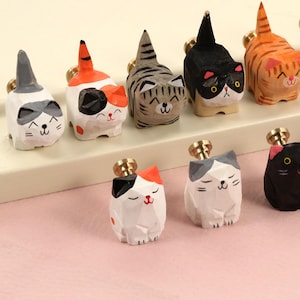 May include: A set of ten wooden cat drawer pulls in various colours and patterns. The pulls are shaped like cats in different poses, including sitting, standing, and lying down.