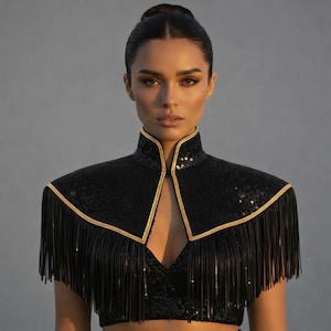 Könnte beinhalten: Schwarzes Pailletten-Bolero mit goldenen Verzierungen und Fransen. Der hohe Kragen und das Schulterdesign erzeugen einen dramatischen Look. Das Bolero wird mit einem passenden schwarzen Oberteil kombiniert.