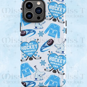 May include: A white phone case with a repeating pattern of ice hockey-themed graphics. The design includes blue hockey jerseys, skates, pucks, snowflakes, and hearts. The text "IN MY HOCKEY ROMANCE ERA" is featured in a heart shape.