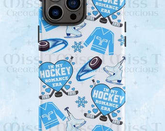 May include: A white phone case with a repeating pattern of ice hockey-themed graphics. The design includes blue hockey jerseys, skates, pucks, snowflakes, and hearts. The text "IN MY HOCKEY ROMANCE ERA" is featured in a heart shape.