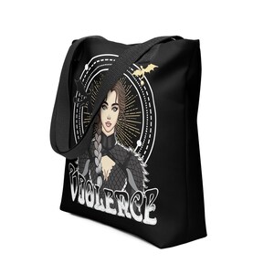 May include: Black tote bag featuring a white graphic of a woman with long, braided hair wearing a black and silver outfit. The woman is surrounded by a circle with a dragon design. The text "VIOLENCE" is printed in white below the woman.