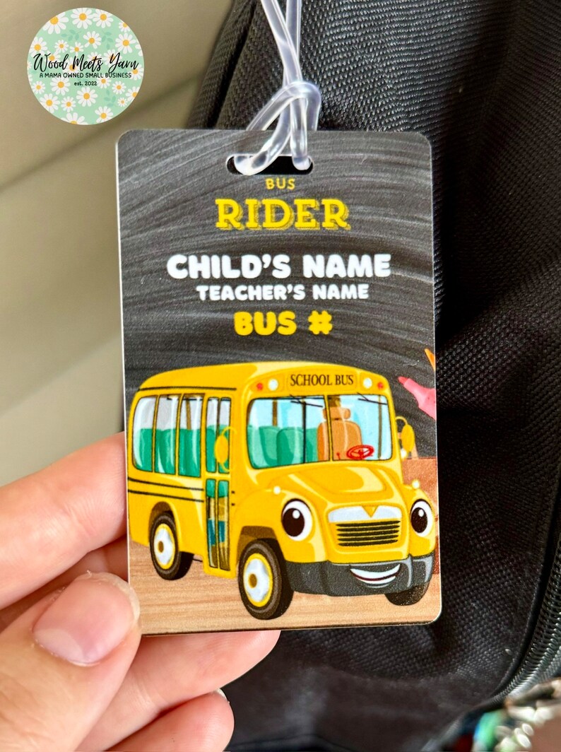 Pu&ograve; includere: Un autobus scolastico giallo con un viso sorridente e le parole "School Bus" sul lato. L'autobus &egrave; su uno sfondo di lavagna nera con il testo "Bus Rider", "Nome del bambino", "Nome dell'insegnante" e "Numero di autobus".