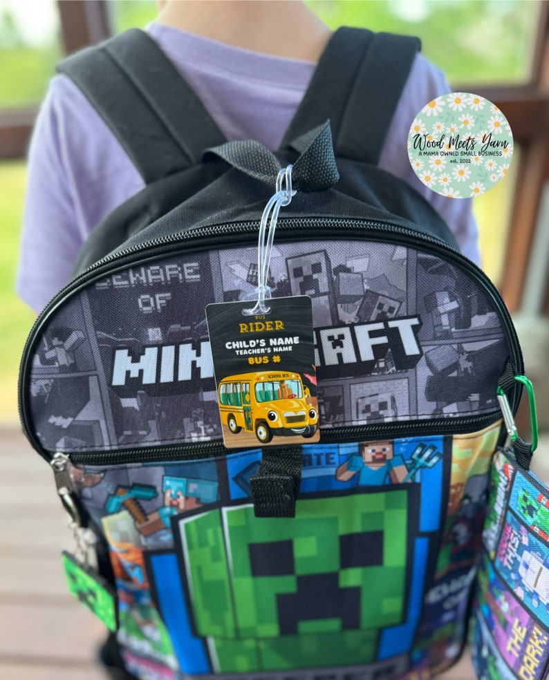 Pu&ograve; includere: Uno zaino nero Minecraft con una faccia di Creeper verde sul davanti. Lo zaino ha una borsa pranzo abbinata con un design Minecraft. Un'etichetta di passeggero dell'autobus &egrave; attaccata allo zaino con il testo "Bus Rider, Child's Name, Teacher's Name, Bus #".