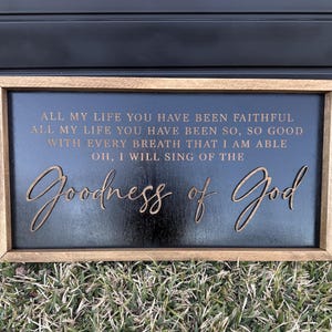 May include: A rectangular wooden sign with a black background and a natural wood frame. The sign features the text: ALL MY LIFE YOU HAVE BEEN FAITHFUL, ALL MY LIFE YOU HAVE BEEN SO, SO GOOD, WITH EVERY BREATH THAT I AM ABLE, OH, I WILL SING OF THE Goodness of God.
