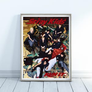 May include: A framed poster featuring the group Stray Kids in a dark, artistic setting. The text Stray Kids appears in red at the top, and the text RUN IT appears in red at the bottom. Eight individuals are posed on a patterned, colorful floor.
