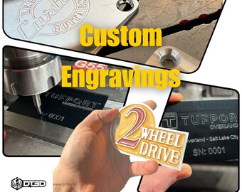 May include: Close-up of a CNC machine engraving a black metal plate with the text "TUFPORT OVERLAND" and "SN: 0001". The machine is also engraving a gold metal plate with the text "LERoy's Custom Guitars".