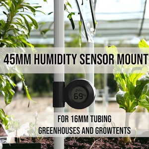 Puede incluir: Un soporte de sensor de humedad negro de 45 mm para tubos de 16 mm, diseñado para invernaderos y tiendas de cultivo. El soporte está unido a un poste blanco y un sensor de humedad negro está unido al soporte. El sensor muestra una temperatura de 24,4 grados Celsius y una humedad del 69%.