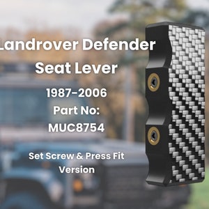 May include: Black carbon fiber seat lever for a Land Rover Defender. The lever has two gold screws and the text "Landrover Defender Seat Lever 1987-2006 Part No: MUC8754 Set Screw & Press Fit Version".