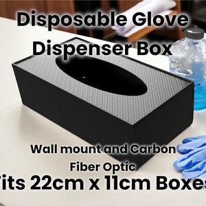 Puede incluir: Una caja dispensadora de guantes desechables de plástico negro con un diseño de fibra óptica de carbono. Está etiquetada como "Disposable Glove Dispenser Box" y "Fits 22cm x 11cm Boxes".