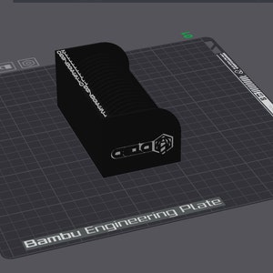 Könnte beinhalten: Ein schwarzes 3D-gedrucktes Objekt mit einer strukturierten Oberfläche und dem Text "Bambu Lab" auf der Vorderseite. Das Objekt befindet sich auf einer grauen, gerasterten Oberfläche mit der Aufschrift "Bambu Engineering Plate".