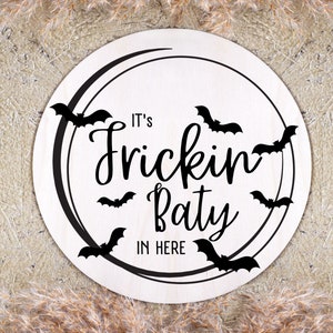 May include: White round wooden sign with black bats and the text "It's Frickin' Party In Here".
