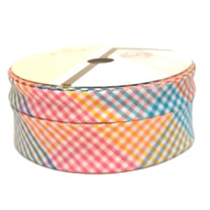 May include: A roll of multi-coloured gingham ribbon in pink, yellow, and blue. The ribbon is wrapped around a cardboard spool, ideal for crafts, gift wrapping, or adding a decorative touch to various projects.