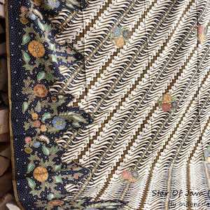 Peut inclure: Un tissu bleu et blanc à motifs avec un motif floral. Le tissu est plié en deux et le texte "Star Of Java (Series 02) By Indonesia Signature" est visible en bas.