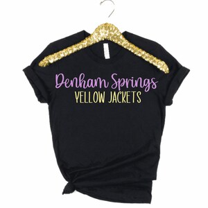 May include: Black t-shirt with purple text that reads "Denham Springs Yellow Jackets".